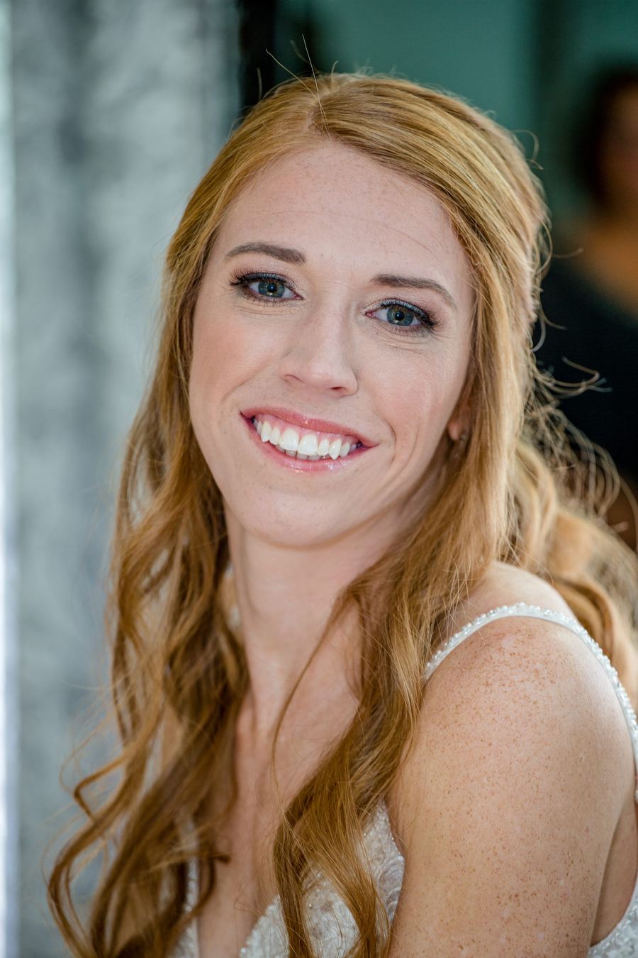 Smiling red-haired bride photographed in soft window light